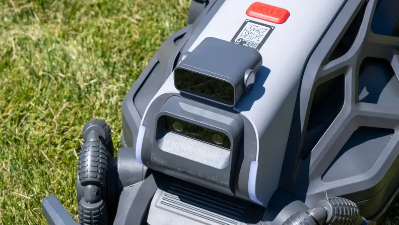 Close-up of wireless mechanism of AirSeekers Tron Robot Lawn Mower on grass.