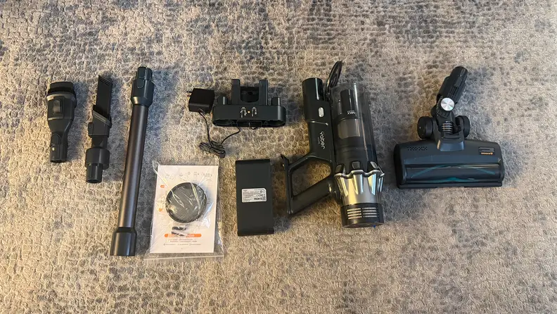 Various parts of Yaber HP20 cordless vacuum laying on a grey carpet.
