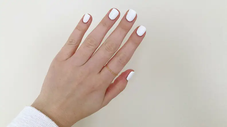 The author wearing Olive & June nail polish shade HD.