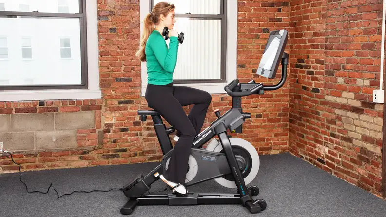 Woman using the NordicTrack S22i sitting up.