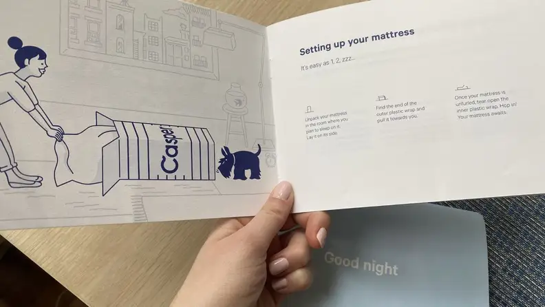 a hand holds the casper mattress brochuer