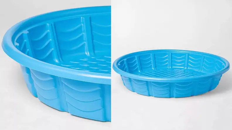 A blue plastic kiddie pool with ridges is photographed on a white background