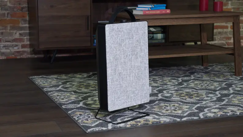 An air purifier stands on a carpet