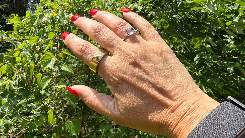 Right hand showing the Luna Ring Gen 2 in front of greenery.