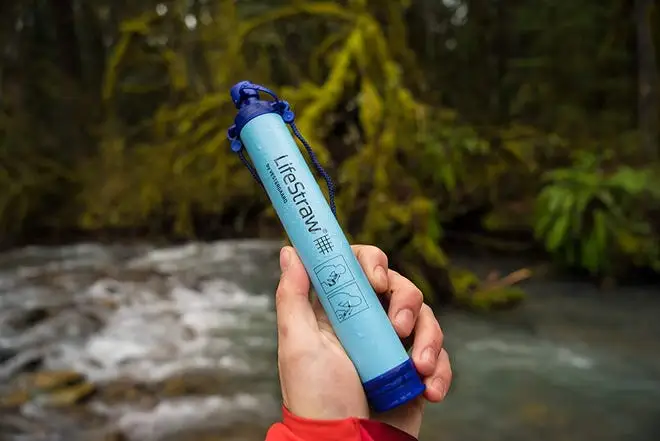 Person holding a LifeStraw outdoors