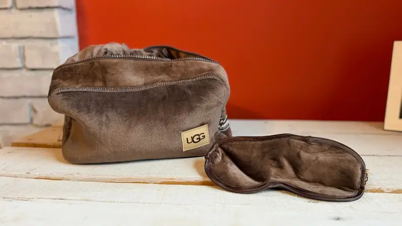 A brown cozy travel bag with a matching eye mask