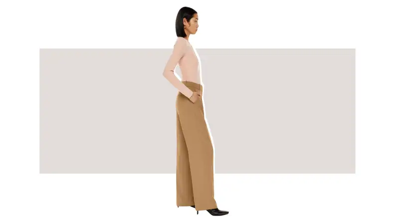 A model wearing tan high-waisted wide-leg trousers.