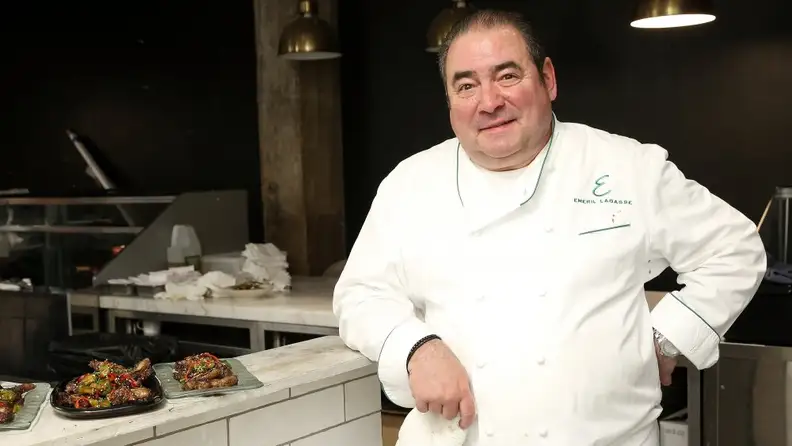 Emeril Lagasse standing by kitchen range