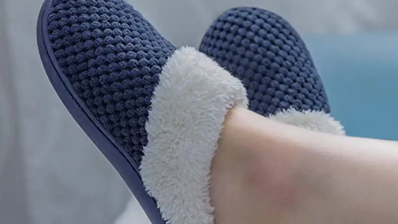 Cozy slippers on a pair of feet.