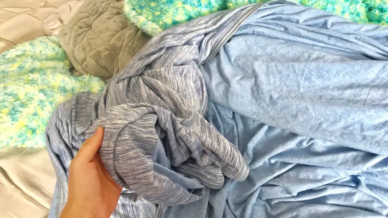 Person using hand to hold up blanket.