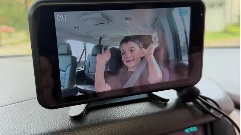 Babyvue BV6 Baby Car Monitor mounted to dashboard with black cables showing on the right.