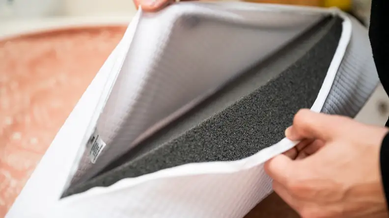 a person unzips the pillow cube to reveal its foam core