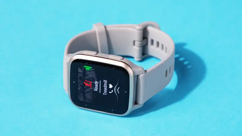 A Garmin Venu Sq 2 fitness tracker rests on a light blue background.