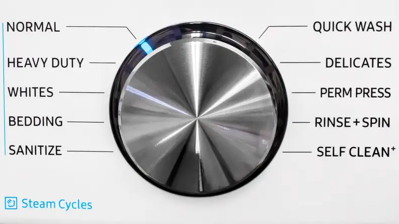 The plain, metallic control dial on the Samsung WF45R6100AW washer. Arranged around it are all the different cycles you can select.