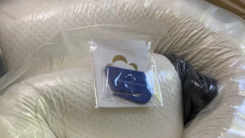 a cutter sitting on top of a new mattress in a box