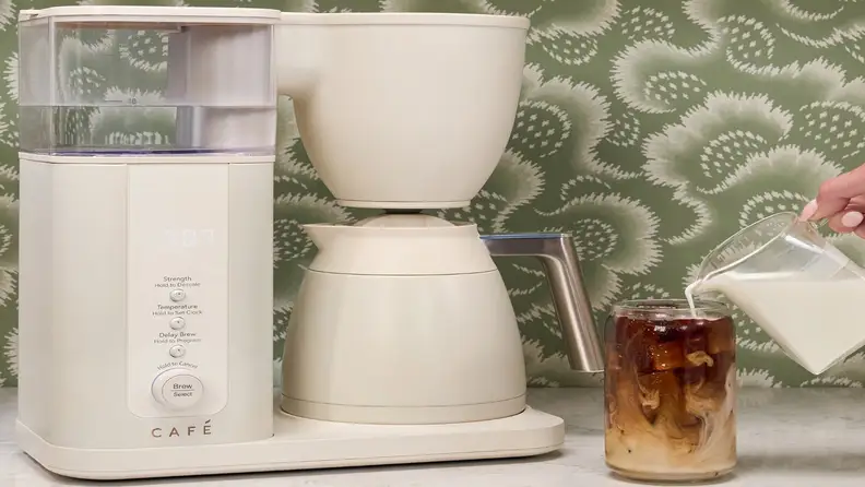 Cream Café coffee maker with milk being poured into iced coffee
