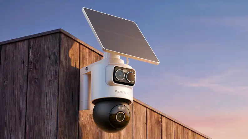 A home security camera perches on the side of a building
