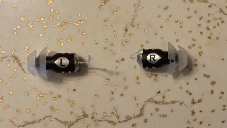 Pair of Eargo SE hearing aids on countertop surface.