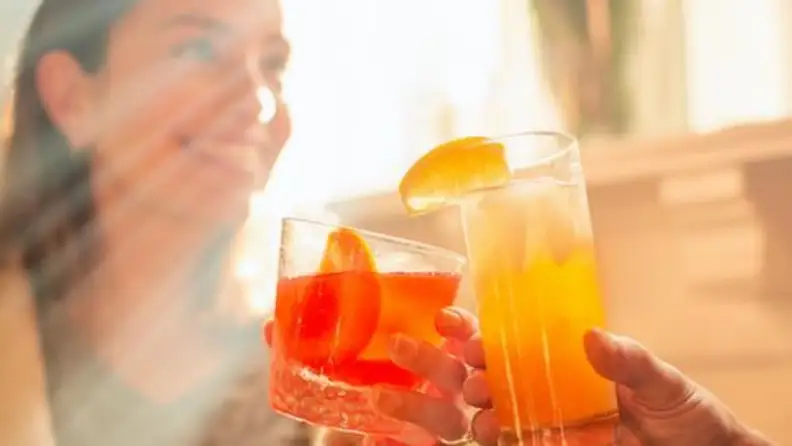 A couple clinks cocktail glasses
