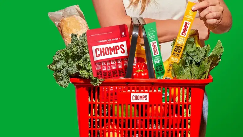 Chomps meat sticks and beef stick packs in a grocery basket with produce