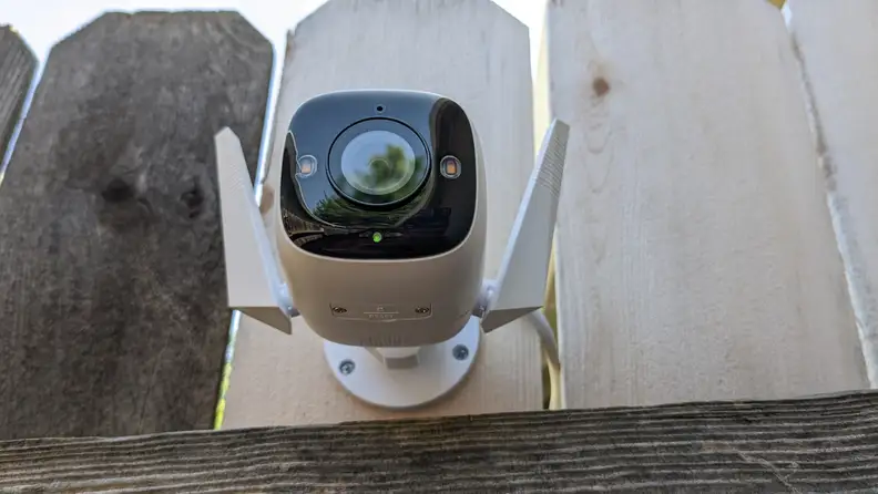 The Tapo camera installed on a wooden fence.