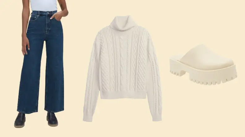 A model wearing wide-leg jeans, a white cable-knit sweater, and a cream clog.