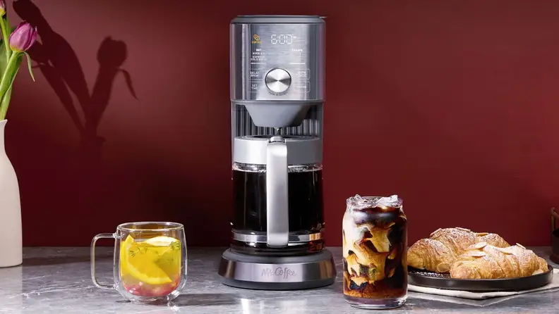 Mr. Coffee machine with a carafe of coffee, iced coffee and croissants