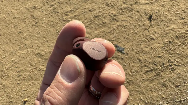 A hand holding the earbud.