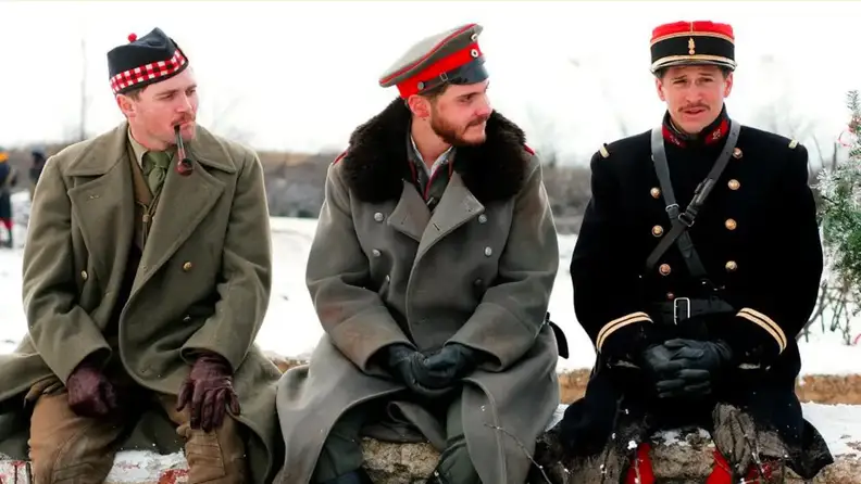 Three solders on the World War I battleflied sit in the snow and discuss life in a scene from Joyeux Noel (2005)
