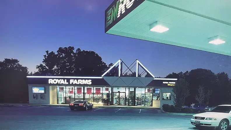 Exterior of a Royal Farms store lit up at dusk