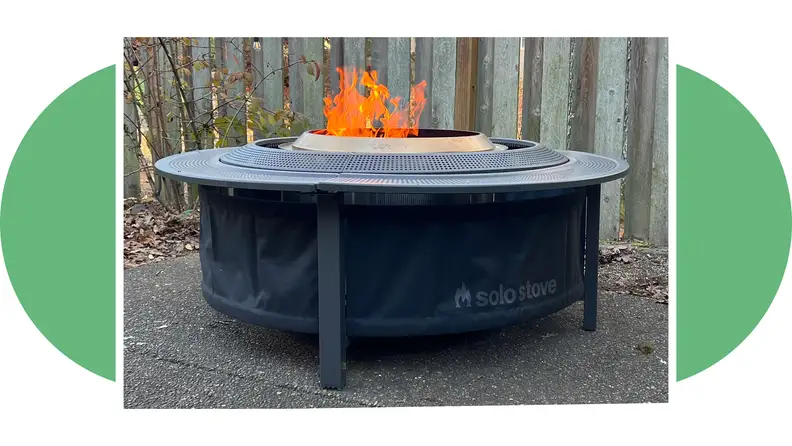 Side view of the Solo Stove Surround with a flame burning in the firepit.