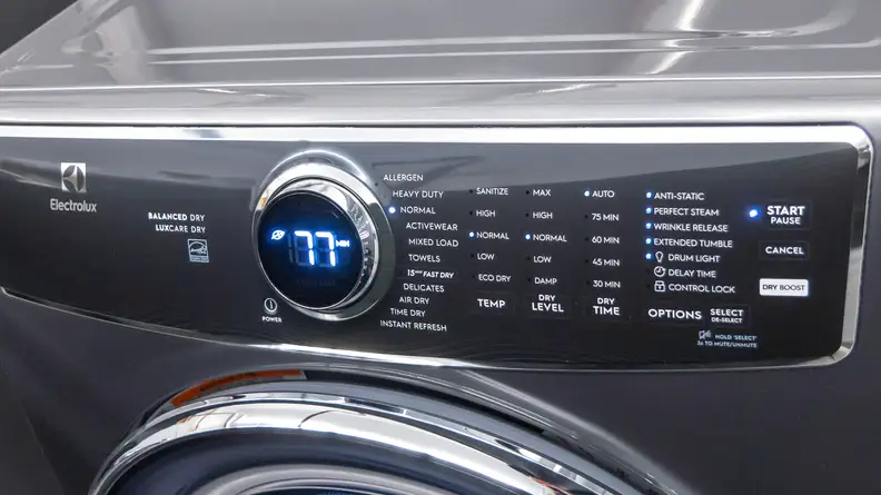 The image shows a dryer’s black interface with white lettering and a round dial in the center that has the number 77 on it.