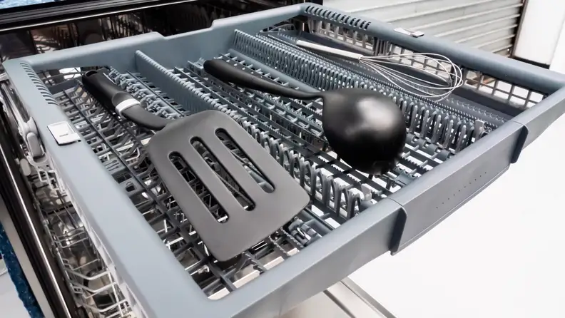 The Bosch 500 Series SHPM65Z55N dishwasher's third rack, pulled out and full of large utensils.