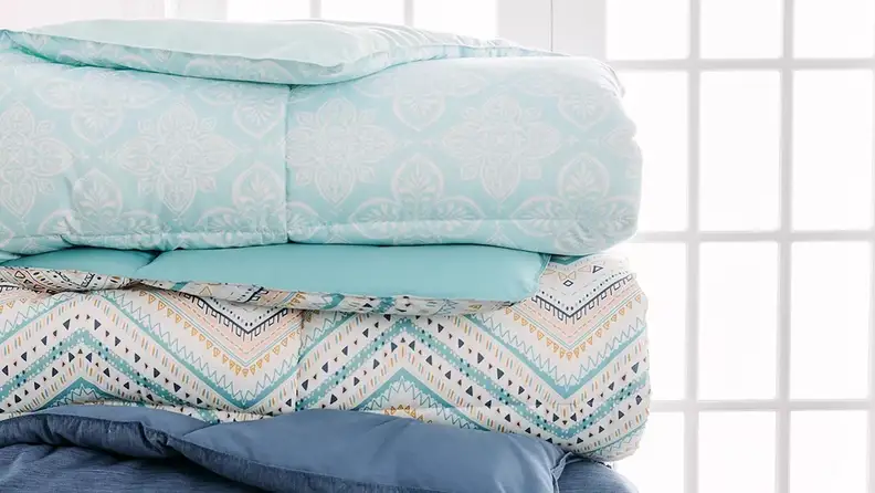 stack of blue comforters by The Big One