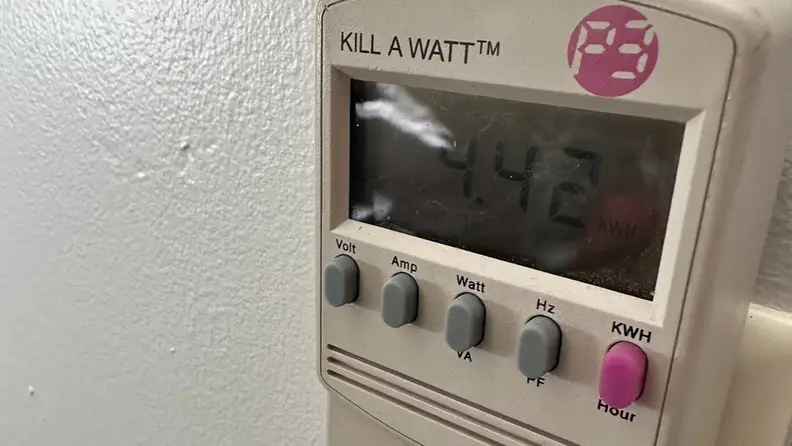 An electricity usage monitor plugged into the wall.