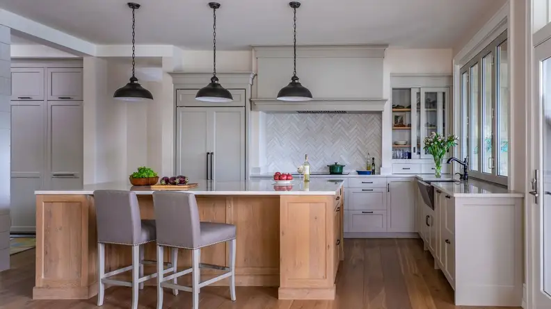 This kitchen, built by New Hampshire company, Jewett Farms, uses warm wood to contrast with gray and white.