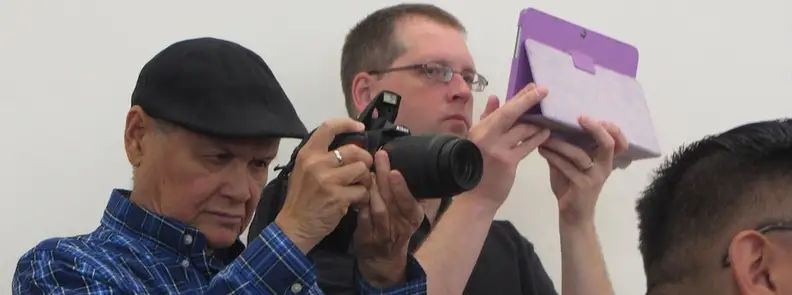 A man taking a photo with a tablet.