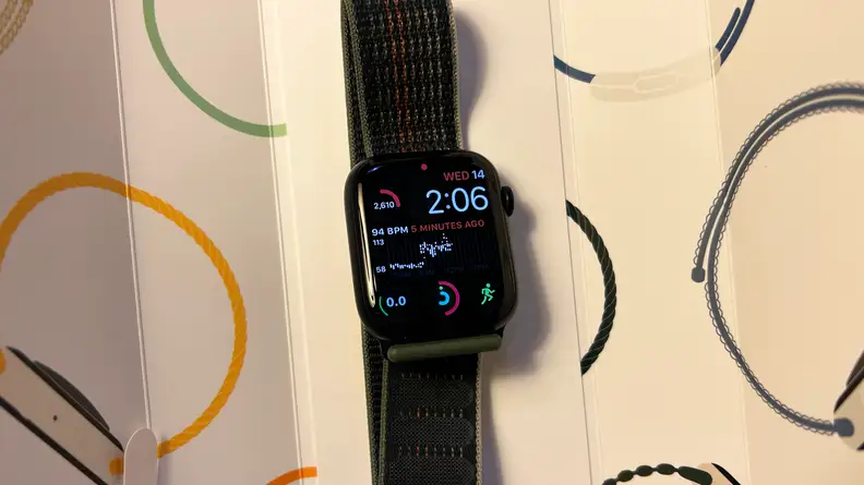 An Apple Watch Series 8 sits in the box with its display on.