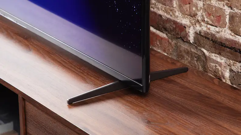 A black and blue corner of the Sony X90K LED TV's screen and its stand legs.