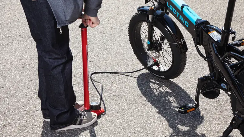 Inflating the front tire of the Lectric XP 3.0 with a floor pump.