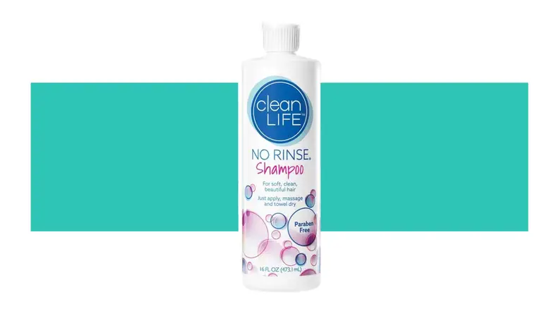 A bottle of No-Rinse Shampoo in front of a background.