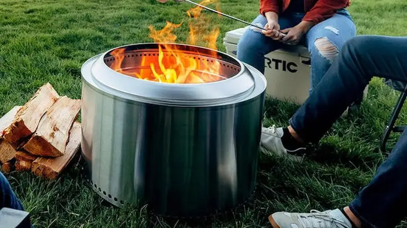A family sits around their Solo Stove fire pit.