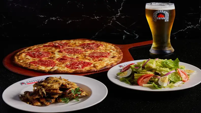 A pepperoni pizza, wings, salad, and a beer from Anthony's