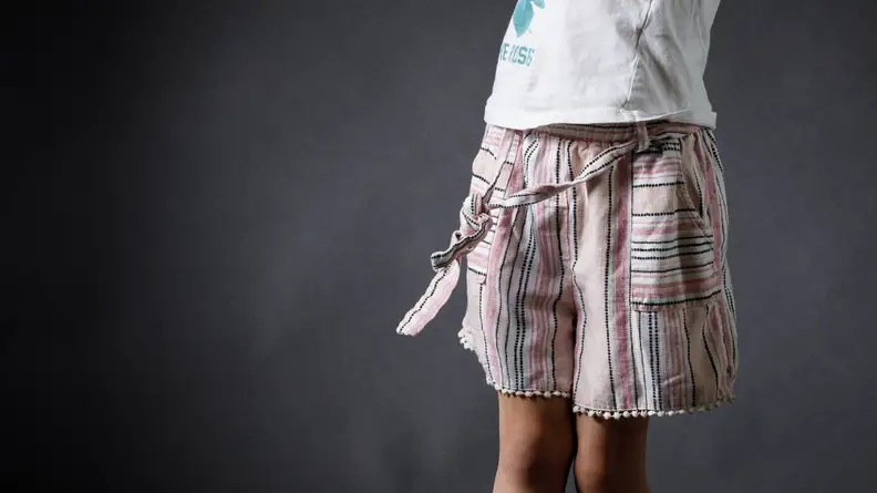 A girl wearing a pair of pink striped shorts and a t-shirt