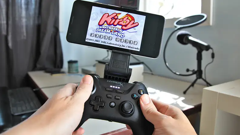 A person plays a video game with the HyperX Clutch game controller.