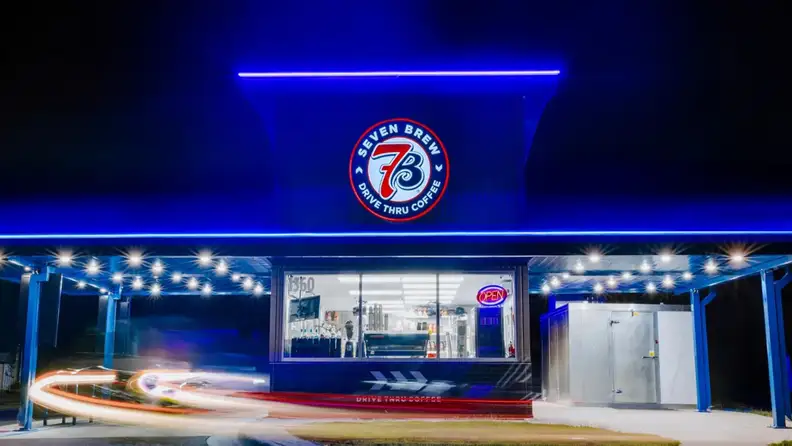 7 Brew drive thru coffee stand lit in blue at night