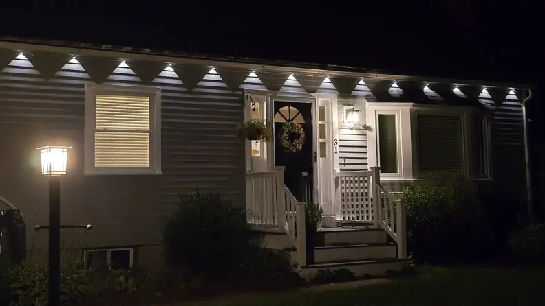 Govee LED Permanent Outdoor Lights 2 Pro illuminated in white hung on a white house.