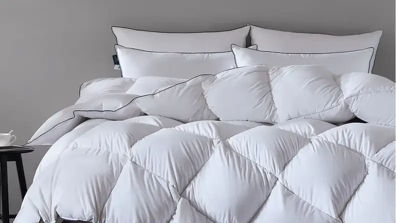 White Pacific Coast Luxury 100% Australian Cotton Goose Down Comforter on a bed with two pillows.