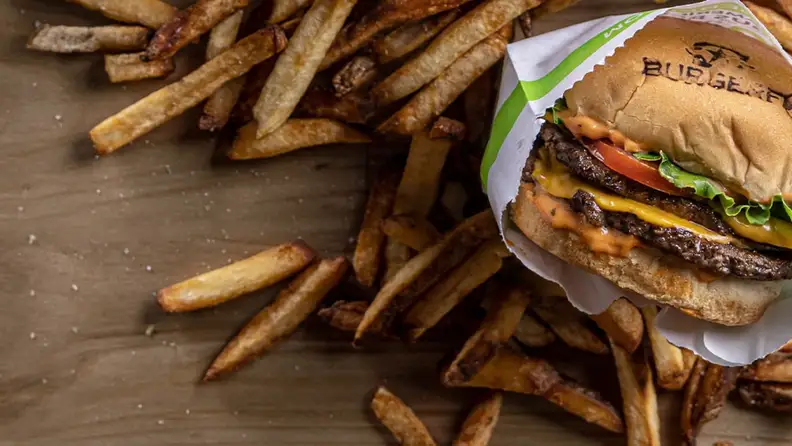 A BurgerFi double cheeseburger surrounded by fries