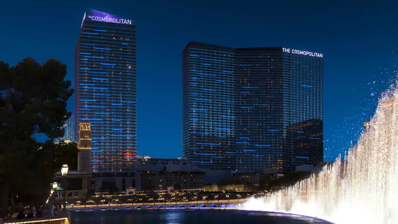 The Cosmopolitan’s twin towers rising above the Las Vegas Strip at night, with illuminated facades overlooking the Bellagio fountains.